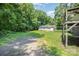 A large backyard with a detached white garage featuring multiple doors, carport and blue tarp at 5275 Long Ferry Rd, Salisbury, NC 28146