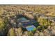 Aerial view of community pool, tennis courts, parking nestled in autumn trees at 5309 Silchester Ln, Charlotte, NC 28215