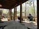 Spacious covered deck with wood pillars overlooking a private backyard with outdoor fireplace and spa at 5309 Silchester Ln, Charlotte, NC 28215