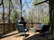 Relaxing deck features comfortable rocking chairs with cushions and an outdoor fireplace with wooded view at 5309 Silchester Ln, Charlotte, NC 28215
