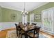 Formal dining room with hardwood floors, crown molding, chandelier, and a large window at 5309 Silchester Ln, Charlotte, NC 28215