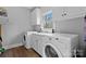 A functional laundry room with washer, dryer, sink, and storage cabinets at 5309 Silchester Ln, Charlotte, NC 28215