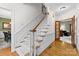 Elegant staircase featuring hardwood steps, white risers, and detailed trim at 5309 Silchester Ln, Charlotte, NC 28215