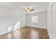 This bedroom includes a ceiling fan, hardwood floors, and a window allowing for natural light at 5909 Quail Hollow Rd # B, Charlotte, NC 28210