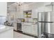 Well-lit kitchen features stainless steel refrigerator, white cabinets, stone countertops, and dine-in table at 5909 Quail Hollow Rd # B, Charlotte, NC 28210