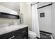 Modern bathroom with sleek black and white tile, a contemporary vanity, and a shower with glass door at 6245 Wheeler Dr, Charlotte, NC 28211