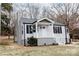 A single-story home with gray vinyl siding, a chimney and a welcoming front porch at 634 Mckee St, Albemarle, NC 28001