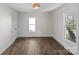 Cozy bedroom with hardwood floors, a modern light fixture, and ample natural light at 691 Gibson Nw Dr, Concord, NC 28025