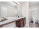 Bathroom showcasing vanity with white countertop, wood cabinets, large mirror, and walk-in shower at 7436 Meridale Forest Dr, Charlotte, NC 28269