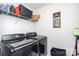 Modern laundry room featuring side-by-side washer and dryer with shelving at 7436 Meridale Forest Dr, Charlotte, NC 28269