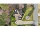 Aerial view of home showcasing roof, yard, patio with fire pit, driveway, and tree-lined property at 7510 Plumcrest Ln, Harrisburg, NC 28075