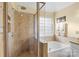 Bright bathroom boasts dual shower and soaking tub with a glass block window at 7510 Plumcrest Ln, Harrisburg, NC 28075