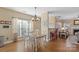 Cozy dining room with hardwood floors, modern light fixture, and natural light from large window at 7510 Plumcrest Ln, Harrisburg, NC 28075