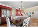Dining room featuring a china cabinet, dark wood table with white chairs, and an adjacent staircase at 7510 Plumcrest Ln, Harrisburg, NC 28075
