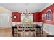 Formal dining room with bright red walls, a large window, and a table set for Gathering gatherings at 7510 Plumcrest Ln, Harrisburg, NC 28075