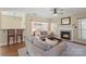 Bright living room with a fireplace, ceiling fan, and comfortable seating, creating a warm and inviting atmosphere at 7510 Plumcrest Ln, Harrisburg, NC 28075