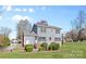 A well-maintained backyard with grass, shrubs, trees, and a two-story home at 9218 Robert Burns Ct, Charlotte, NC 28213