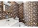 Charming powder room featuring floral wallpaper, a decorative mirror, and a clean white vanity at 9218 Robert Burns Ct, Charlotte, NC 28213
