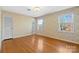 Bright bedroom features hardwood floors, floral wallpaper, and two windows at 9218 Robert Burns Ct, Charlotte, NC 28213