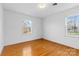 Bright bedroom featuring hardwood floors, white walls, and two windows at 9218 Robert Burns Ct, Charlotte, NC 28213