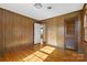 Wood-paneled bedroom featuring hardwood floors and natural lighting from two windows at 9218 Robert Burns Ct, Charlotte, NC 28213