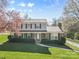Inviting two-story home showcasing a well-kept lawn, brick accents, and a cozy covered porch at 9218 Robert Burns Ct, Charlotte, NC 28213