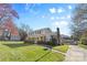 Two-story brick home features a manicured lawn, mature tree, and covered porch at 9218 Robert Burns Ct, Charlotte, NC 28213