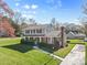 Charming two-story home featuring a brick chimney, covered porch, and a lush, well-manicured lawn at 9218 Robert Burns Ct, Charlotte, NC 28213