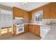 Well-lit kitchen with wood cabinets, white appliances, and classic design elements at 9218 Robert Burns Ct, Charlotte, NC 28213
