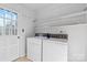 Functional laundry area with washer, dryer, and built-in storage shelves at 9218 Robert Burns Ct, Charlotte, NC 28213