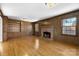 Charming living room with wood paneling, brick fireplace, and built-in shelving at 9218 Robert Burns Ct, Charlotte, NC 28213