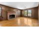 Cozy living room featuring a brick fireplace and ample natural light from multiple windows at 9218 Robert Burns Ct, Charlotte, NC 28213