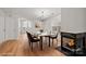 Open concept dining room with modern chandelier, fireplace and wood flooring at 9912 Birch Knoll Ct, Charlotte, NC 28213