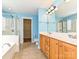 Bathroom featuring dual sinks, ample cabinet space, a walk-in shower, and a tub with tile surround at 10133 Caldwell Forest Rd, Charlotte, NC 28213
