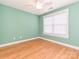 Bright bedroom features a ceiling fan, wood-look flooring, and a large window letting in lots of light at 10133 Caldwell Forest Rd, Charlotte, NC 28213