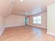 Large bonus room has wood flooring, ceiling fan, and lots of natural light from the window at 10133 Caldwell Forest Rd, Charlotte, NC 28213