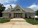 Stately community clubhouse featuring stone accents, a covered entrance, and beautifully landscaped grounds at 10133 Caldwell Forest Rd, Charlotte, NC 28213