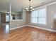 Open dining area with hardwood floors and chandelier next to a living room with nice windows at 10133 Caldwell Forest Rd, Charlotte, NC 28213