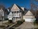 Two-story home featuring a charming front porch and a convenient two-car garage at 10133 Caldwell Forest Rd, Charlotte, NC 28213