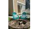 Relax in your backyard at the fire pit with teal Adirondack chairs and decorative pillows for an elevated outdoor experience at 10133 Caldwell Forest Rd, Charlotte, NC 28213