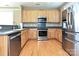 Well lit kitchen featuring stainless steel appliances, hardwood floors, and wooden cabinets at 10133 Caldwell Forest Rd, Charlotte, NC 28213