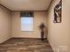 Neutral bedroom with wood-look floors, window with blinds, and artistic wall decorations at 119 Jack Adams Rd, Kings Mountain, NC 28086