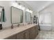 A bathroom featuring dual sinks, marble countertops, a soaking tub, and sleek modern fixtures at 123 Southhaven Dr, Mooresville, NC 28117