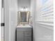 A half bathroom with a gray vanity, framed mirror, and a window providing ample natural light at 123 Southhaven Dr, Mooresville, NC 28117