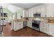 A kitchen with stainless steel appliances, granite countertops, hardwood floors, and cream colored cabinets at 123 Southhaven Dr, Mooresville, NC 28117