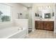 Bright bathroom featuring dual sinks, a glass enclosed shower, a large tub, and tile floors at 128 Millen Dr, Mooresville, NC 28115
