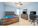 Light blue bedroom features a wooden bed frame, ceiling fan, and dark wooden dresser with TV on top at 128 Millen Dr, Mooresville, NC 28115