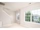 Bonus room with two windows offering lots of natural light, carpet floors and an open stairway at 128 Millen Dr, Mooresville, NC 28115