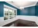 Bright dining room with large windows, dark wood floors, and teal accent wall at 128 Millen Dr, Mooresville, NC 28115