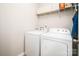 Cozy laundry room equipped with a washer, dryer and shelving for storage of laundry products at 128 Millen Dr, Mooresville, NC 28115